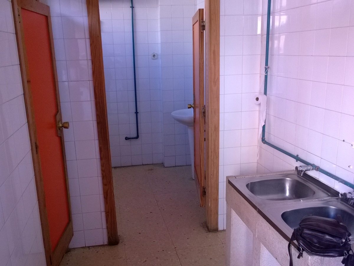 Aseos de colegio en su estado original, con la instalación y los sanitarios antiguos