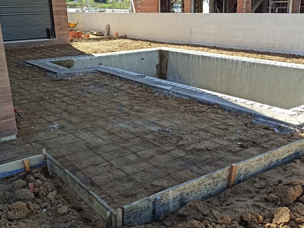 Vaso de la piscina ejecutado en obra, con el terreno todavía sin urbanizar alrededor