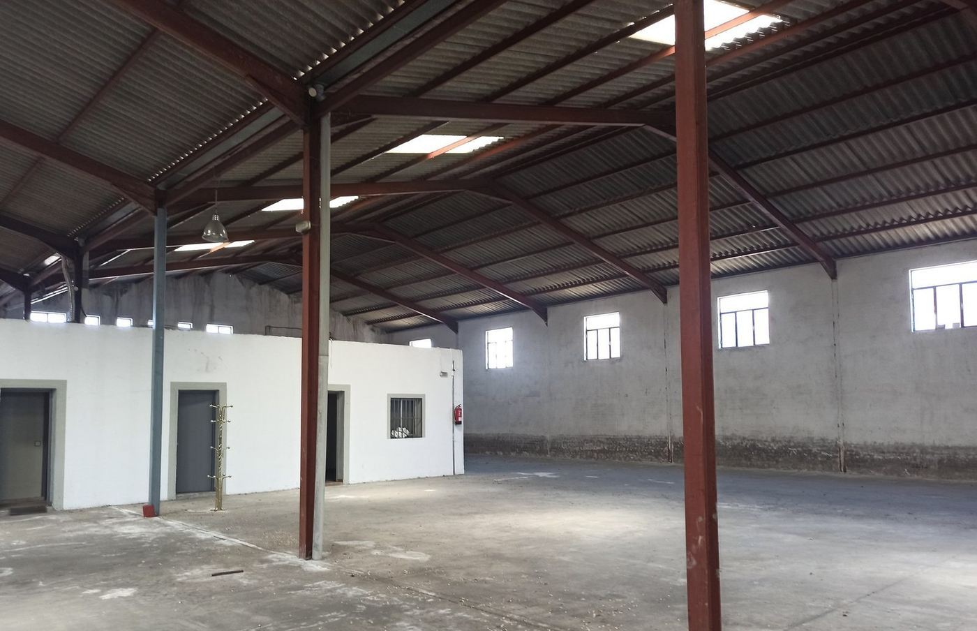 Interior de nave industrial rehabilitada, espacio diáfano con la estructura metálica vista