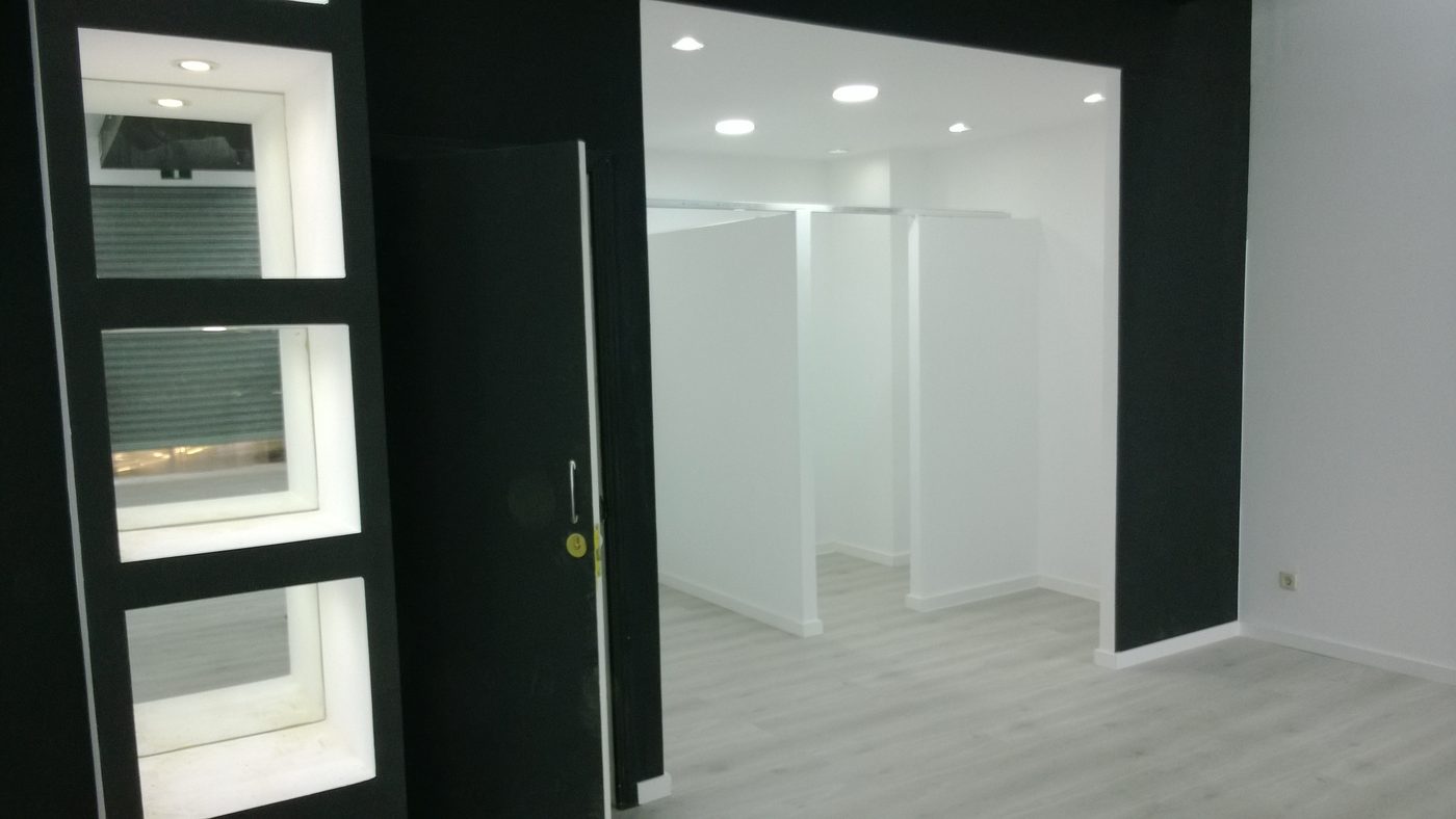 Local comercial diáfano terminado en blanco y negro, con iluminación empotrada